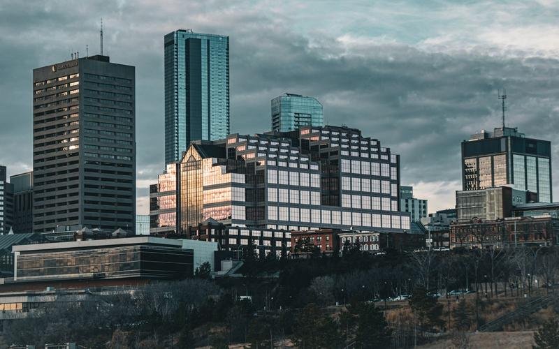 Downtown Edmonton's skyline at dusk, a glass tower catching the last of the sun