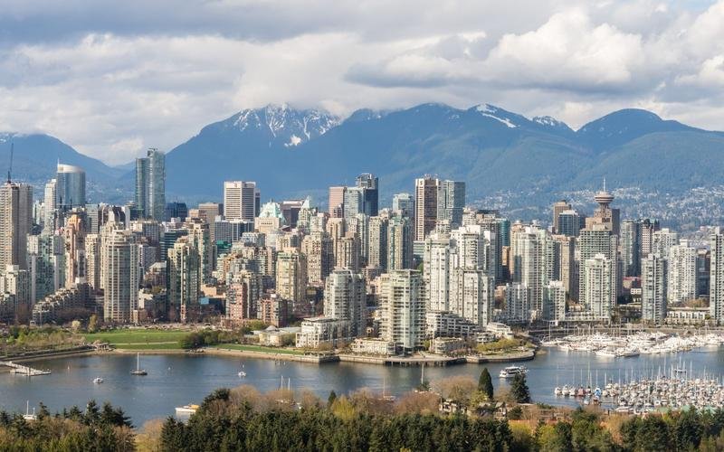 Vancouver's downtown towers between a marina and snow-capped mountains