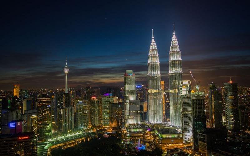 Kuala Lumpur at night, the Petronas Towers and the KL Tower lit above the city